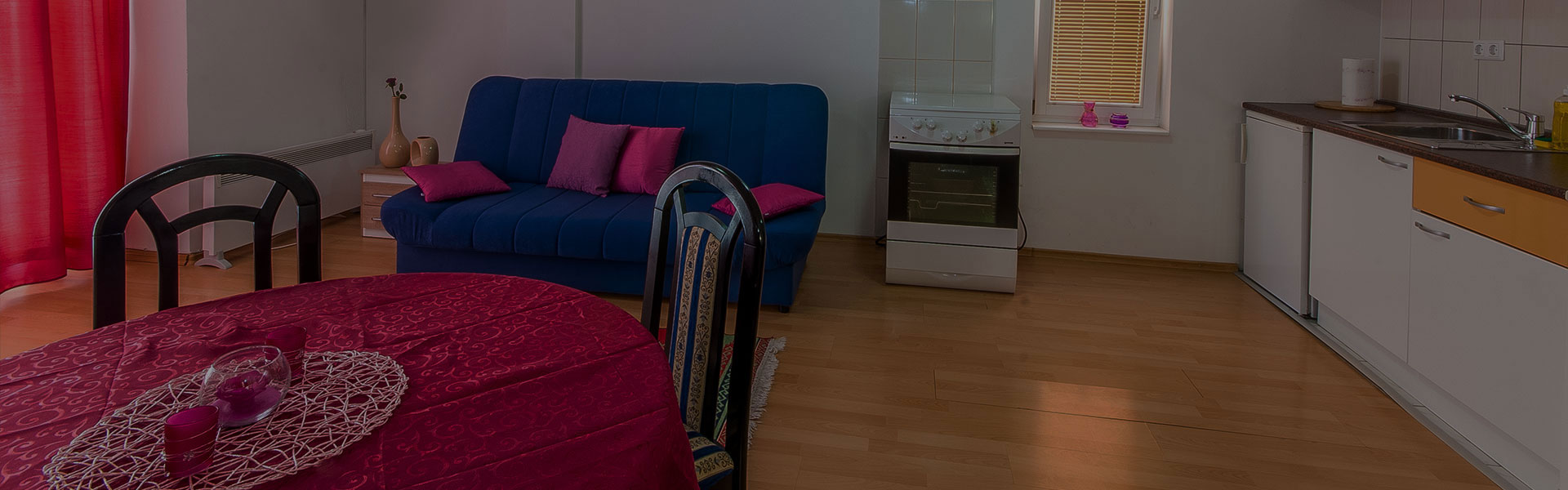 Apartman Tayra pogled na dnevni boravak sa kaučem na razvlačenje i opremljenom kuhinjom sa štednjakom, frižiderom te kuhalom